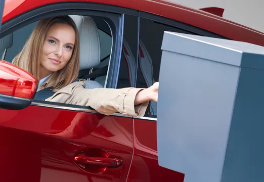 Driver using an access control terminal to enter a secure company car park.