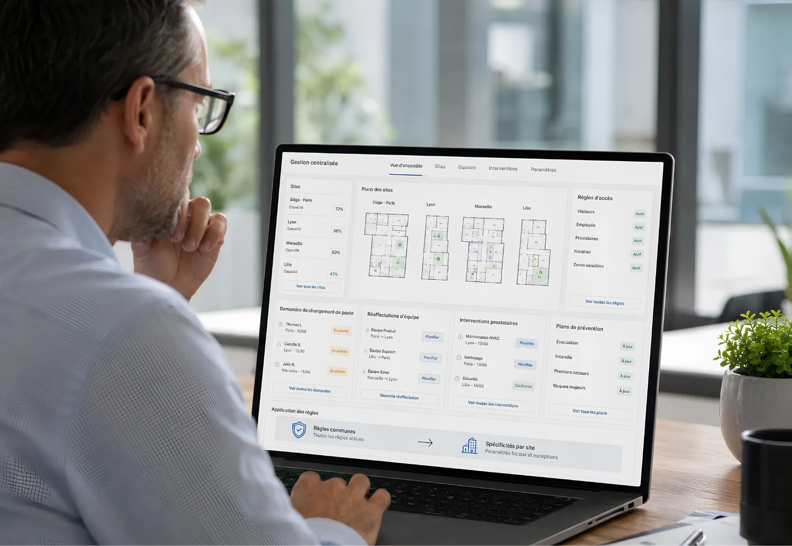 Manager viewing a workspace management dashboard with occupancy rates and floor plans for several sites.