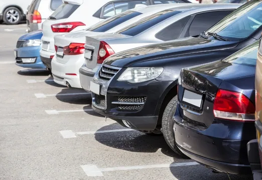 Row of cars parked in car park spaces, illustrating employee parking management in the workplace.