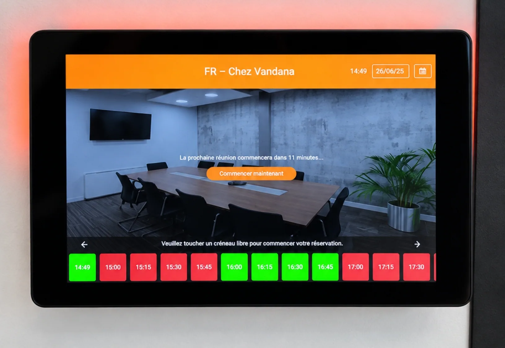 Tablet at the entrance to a meeting room showing available and booked slots to make booking easier