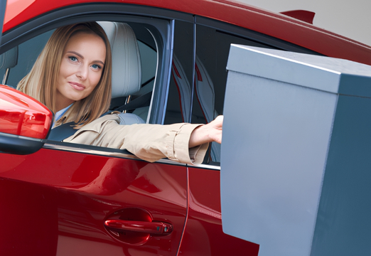 Driver using an access control terminal to enter a secure company car park.
