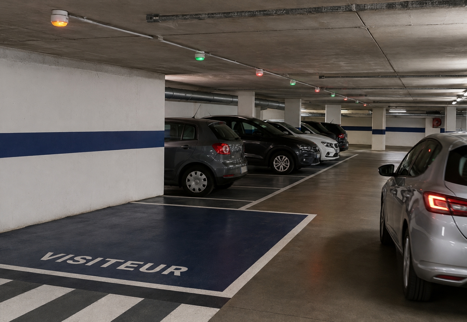 Visitor parking space in an underground company car park, with floor markings.