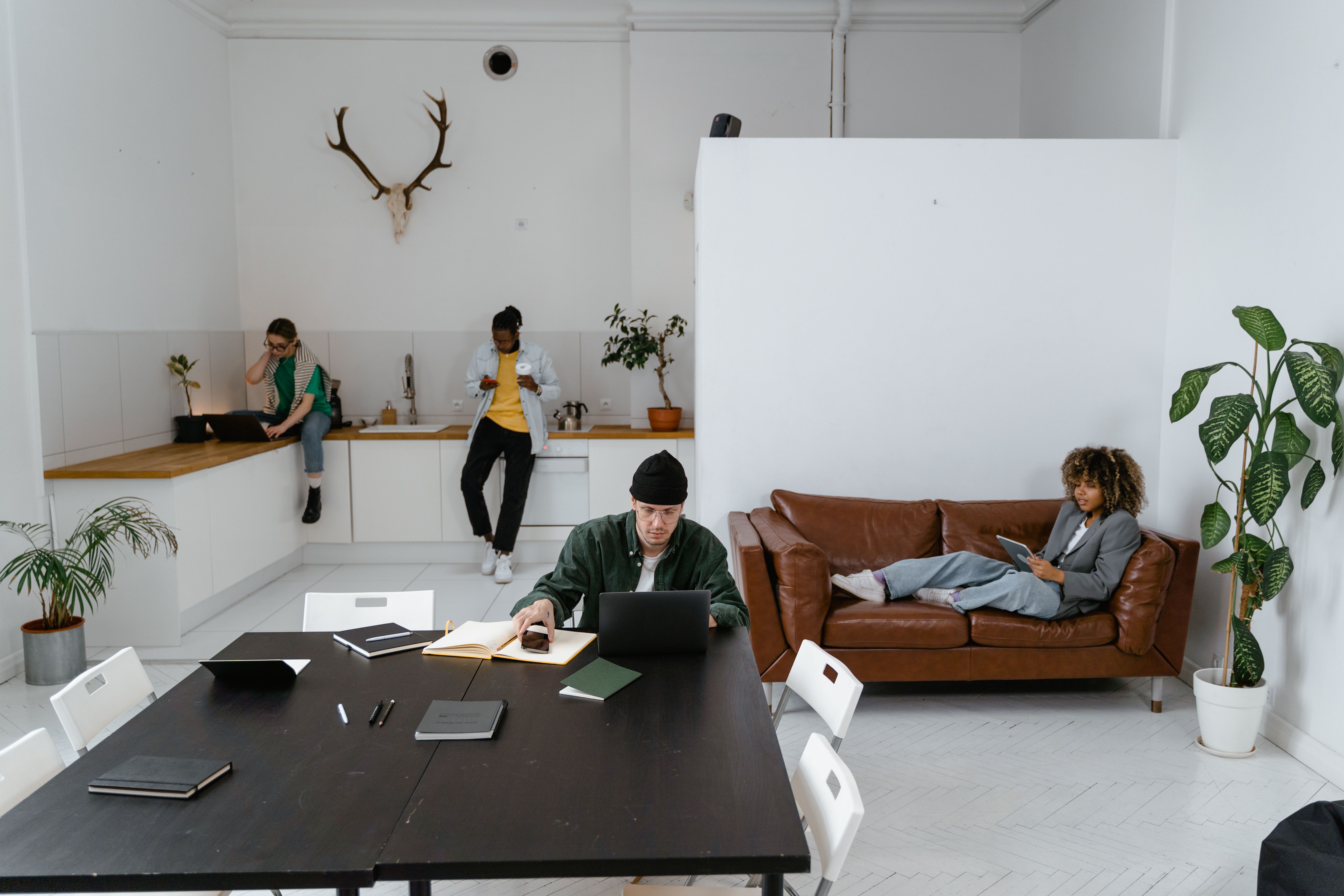 Employees working in a shared space with workstations and breakout areas designed for hybrid working.